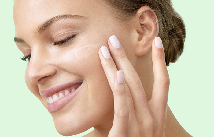 Mano de una mujer sosteniendo un recipiente de vidrio de laboratorio. Artistry; ingredientes naturales probados para el cuidado de la piel 